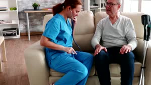Stock Video Home Care Nurse Checks Sick Man With Stethoscope Animated Wallpaper