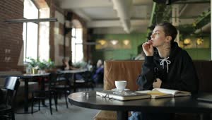 Stock Video Hip Woman Thinking In Cafe Writes Down Idea Animated Wallpaper