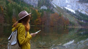 Stock Video Hiking Woman Looking At Map At The Lake Shore Animated Wallpaper