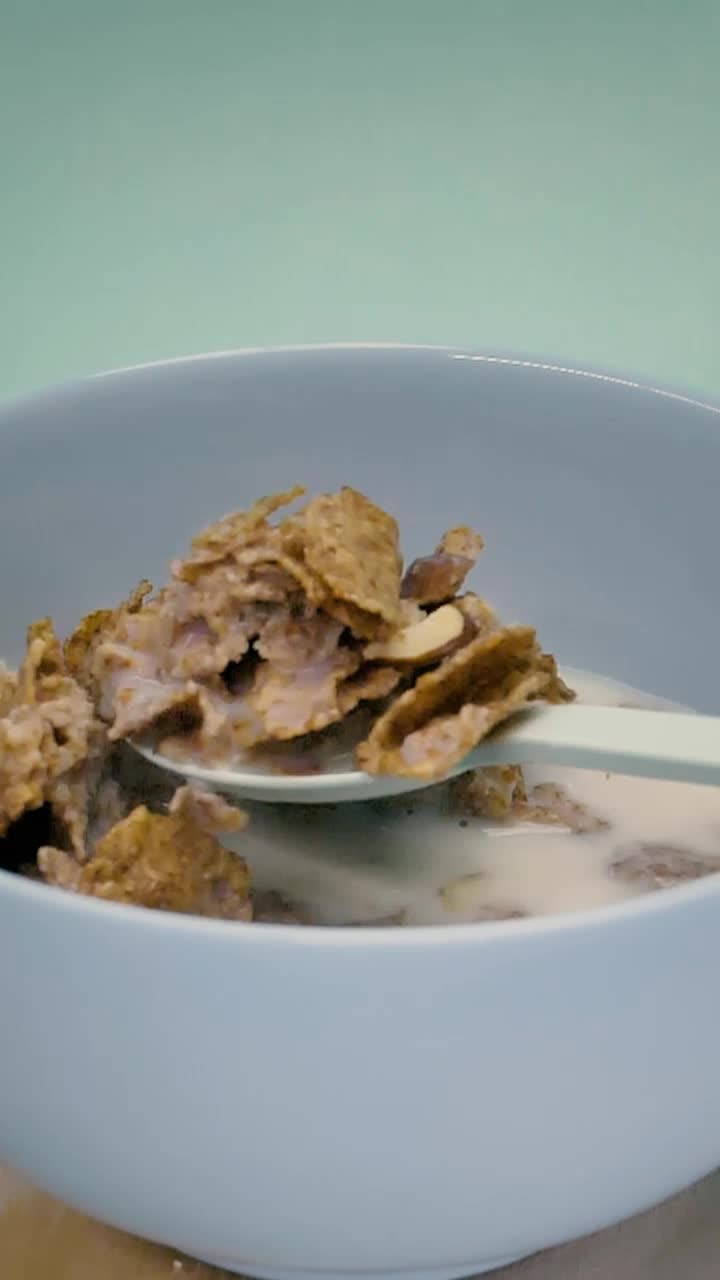 Download Stock Video Having A Tablespoon Of Healthy Cereal With Milk Animated Wallpaper