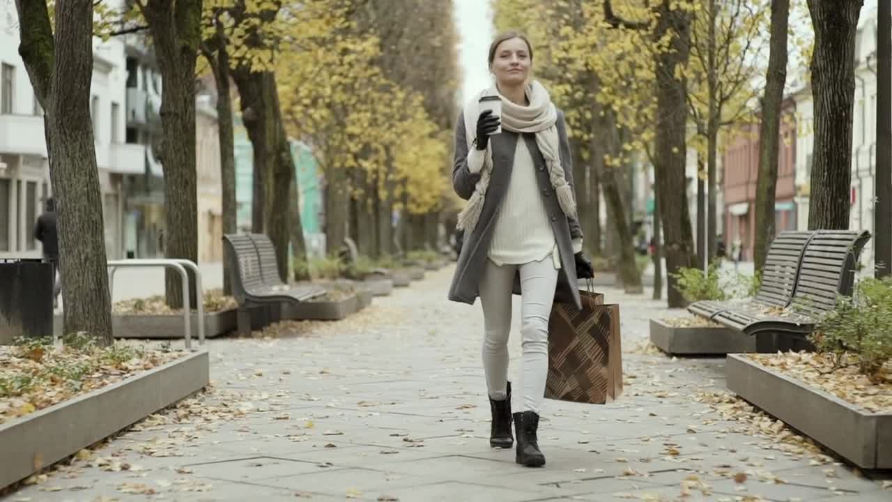 Download Stock Video Happy Woman Walking With Shopping Bags At Autumn Animated Wallpaper