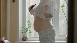 Stock Video Happy Pregnant Woman By The Window Animated Wallpaper