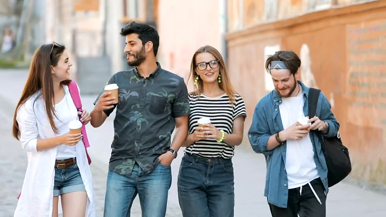 Download Stock Video Happy Friends Walk Down The Street While Talking Animated Wallpaper