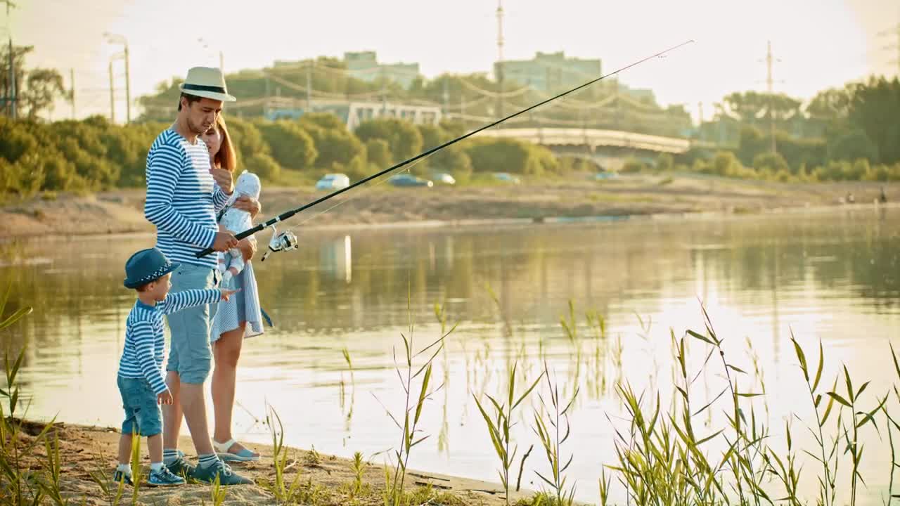 Download Stock Video Happy Family Fishing On The Shore Of A Lake Animated Wallpaper