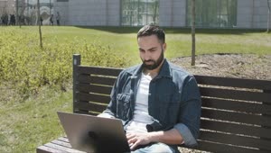 Stock Video Handsome Arab Man Sitting On Park Bench With Laptop Animated Wallpaper