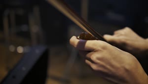 Stock Video Hands Of A Violinist Putting Pitch To Her Violin Bow Animated Wallpaper