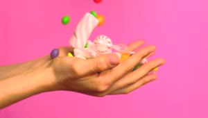 Stock Video Hands Of A Person Full Of Sweets On A Pink Animated Wallpaper