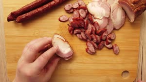 Stock Video Hands Of A Person Cutting Sausages On A Board Animated Wallpaper