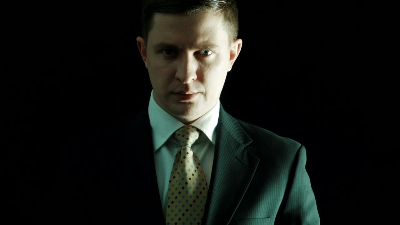 Download Stock Video Man In A Suit Putting Money On His Mouth Animated Wallpaper