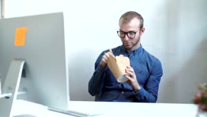 Stock Video Man Eats Chinese Food On Work Break In Office Animated Wallpaper