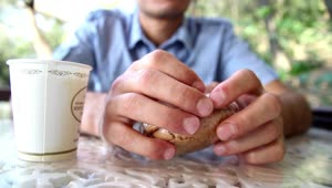 Stock Video Man Eating A Cookie With Coffee At Outdoors Animated Wallpaper