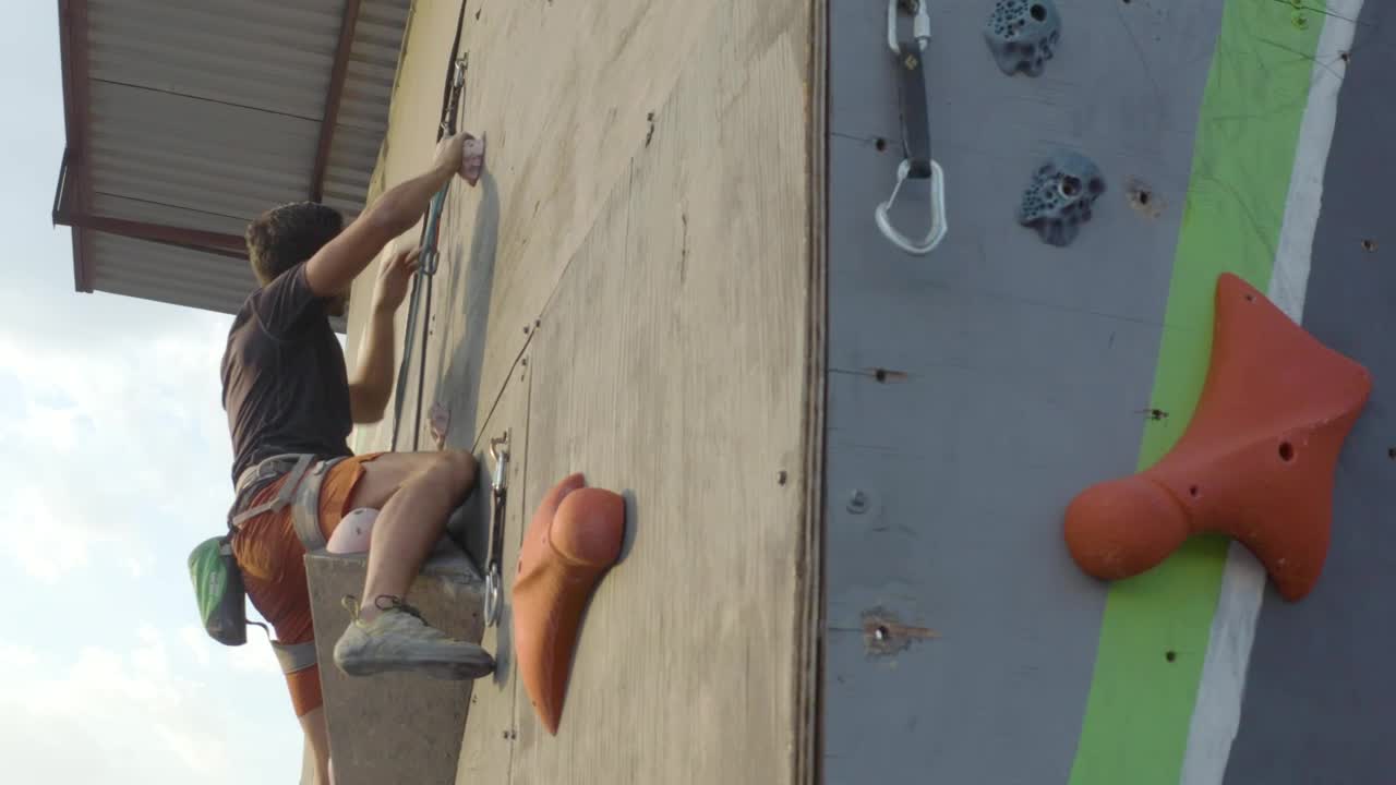 Download Stock Video Man Climbing On Top Of A Mountaineering Tower Animated Wallpaper