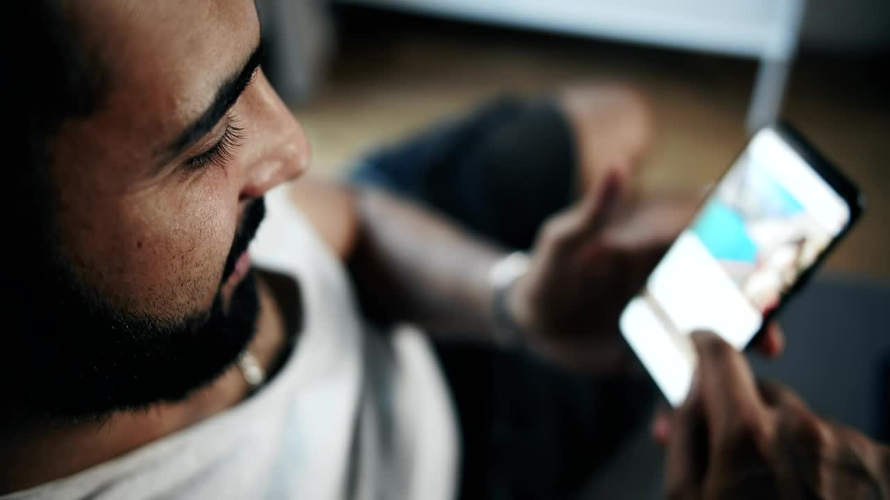 Download Stock Video Man Browsing Social Media On Smartphone Top View Animated Wallpaper