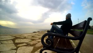 Stock Video Man Admiring The Sea On A Bench At The Pier Animated Wallpaper