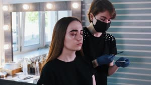 Stock Video Makeup Artist With Medical Mask Working On A Womans Eyebrows Animated Wallpaper
