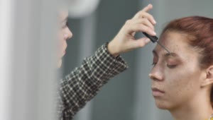 Stock Video Makeup Artist Putting Makeup On The Eyebrows Of A Young Animated Wallpaper