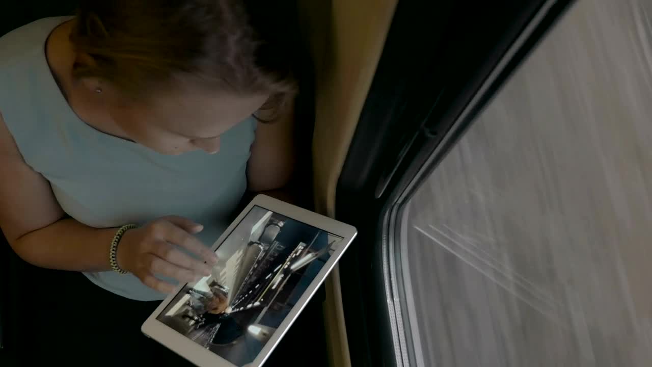 Download Stock Video Looking At Photos On A White Tablet Animated Wallpaper