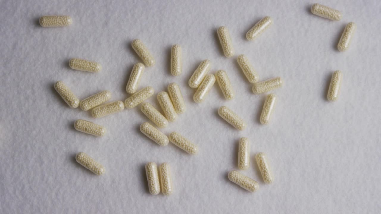 Download Stock Video Little White Pills On A White Texture Animated Wallpaper
