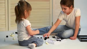 Stock Video Little Sisters Playing Chess On The Floor Animated Wallpaper