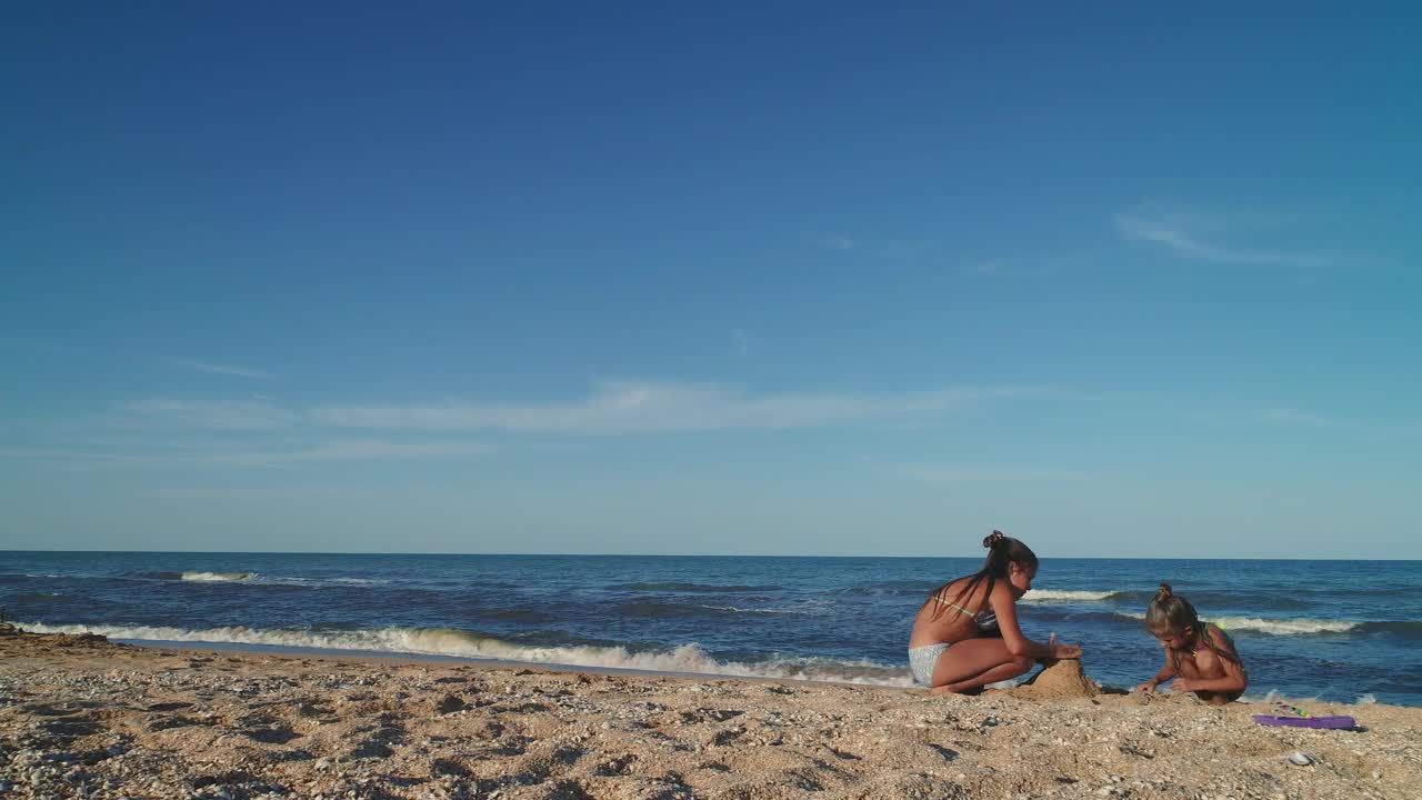 Download Stock Video Little Sisters Making Castles In The Sand Animated Wallpaper