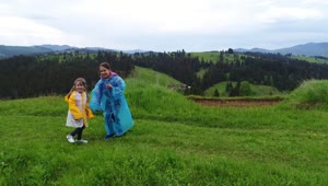 Stock Video Little Girls Using Raincoat On The Meadow Animated Wallpaper