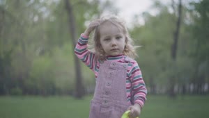 Stock Video Little Girl With Oversized Crown Plays In Park Animated Wallpaper