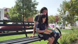 Stock Video Little Girl With Her Mom Reading Together In A Park Animated Wallpaper