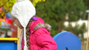 Stock Video Little Girl With A Winter Hat On The Playground Animated Wallpaper