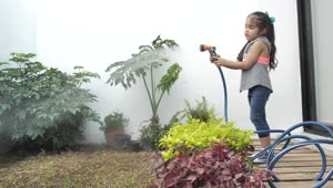 Stock Video Little Girl Watering Her Home Garden With A Hose Animated Wallpaper