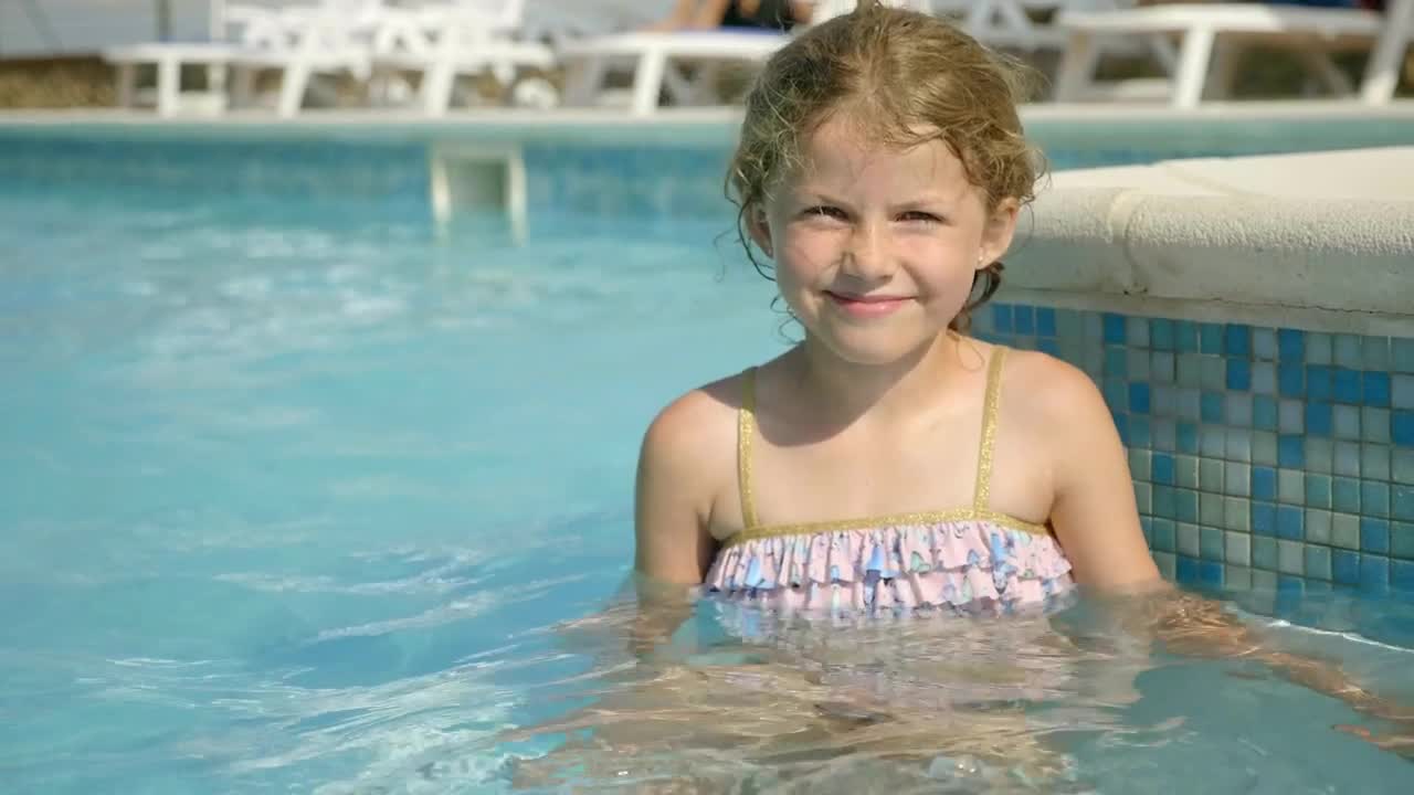 Download Stock Video Little Girl Sitting In Pool And Smiling Animated Wallpaper