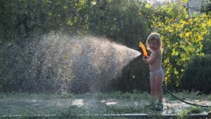 Stock Video Little Girl Playing With The Water Hose Animated Wallpaper