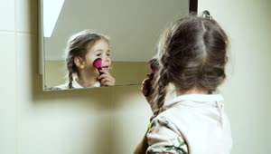 Stock Video Little Girl Playing Makeup In The Mirror Animated Wallpaper