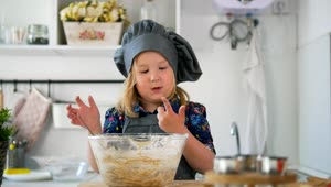 Stock Video Little Girl In A Kitchen Stirring A Cookie Mix Animated Wallpaper