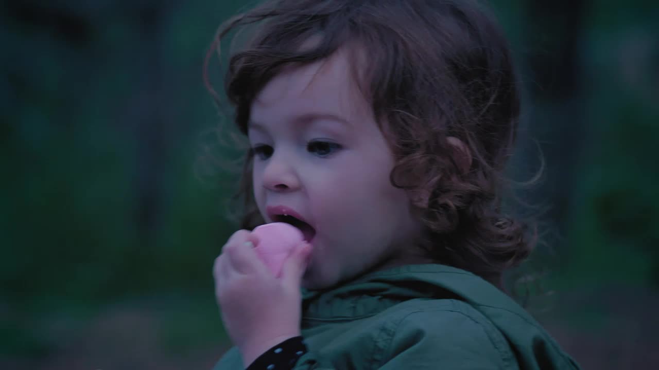 Download Stock Video Little Girl In Nature Eating A Marshmallow Animated Wallpaper