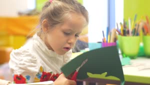 Stock Video Little Girl Cutting Paper In A Kindergarten Classroom Animated Wallpaper