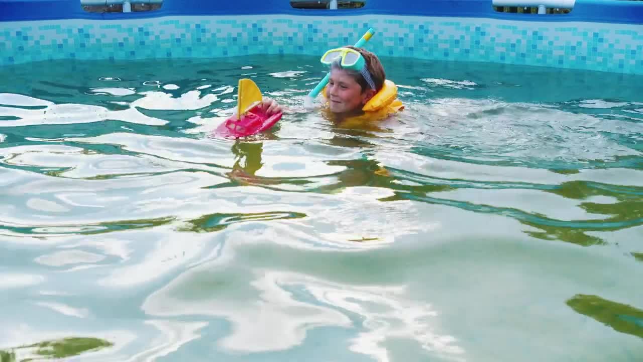 Download Stock Video Little Boy Swimming In A Pool With A Toy Boat Animated Wallpaper