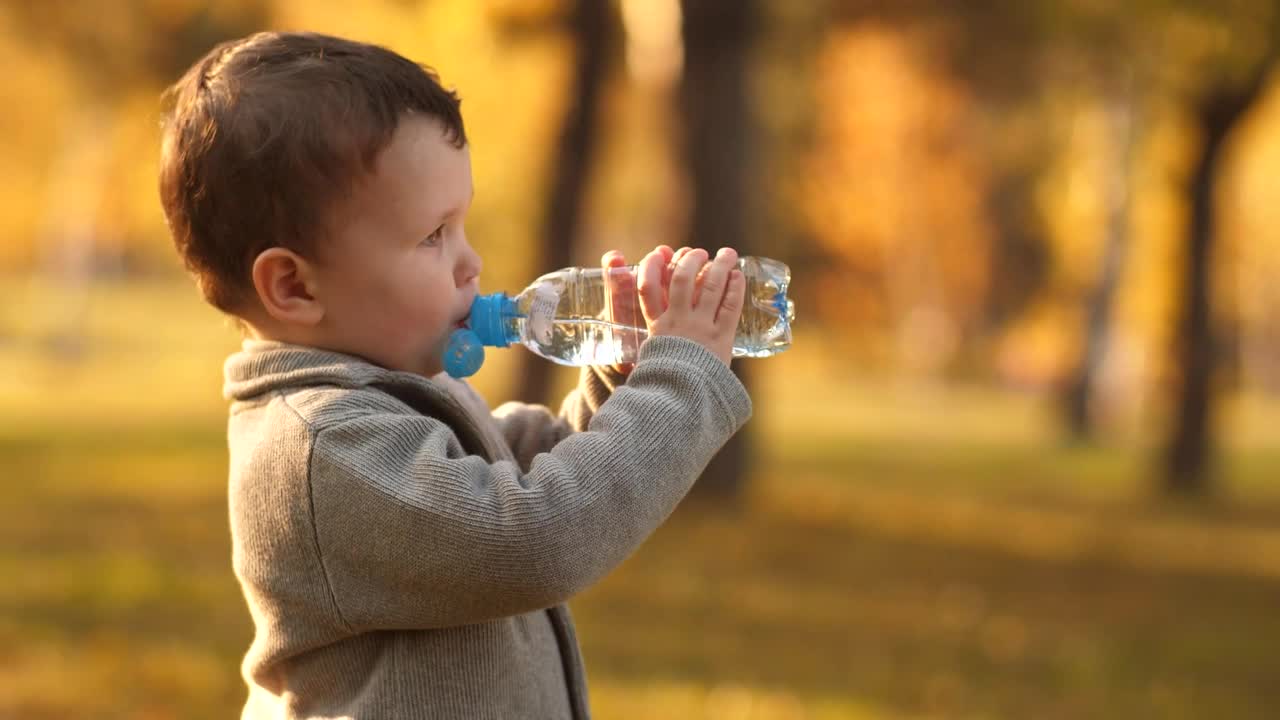 Download Stock Video Little Boy Drinking Water From A Bottle Animated Wallpaper
