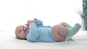 Stock Video Little Baby Lying On His Back Wearing Blue Pajamas Animated Wallpaper