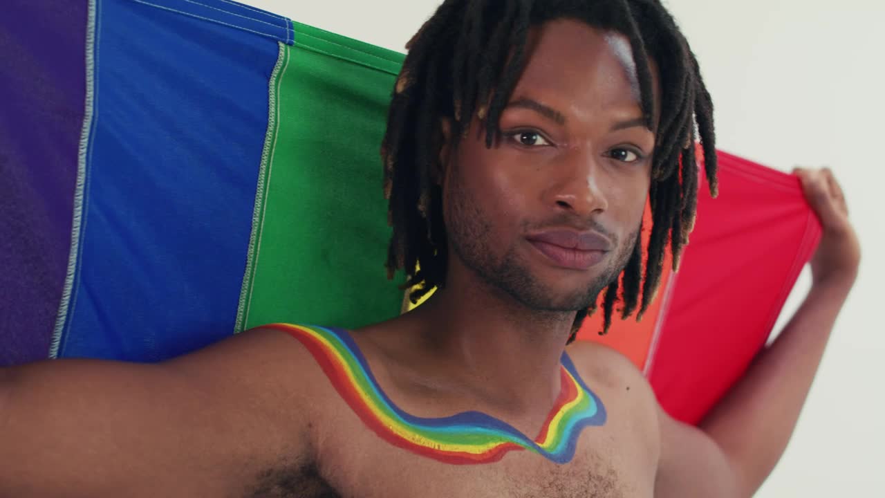 Download Stock Video Lgbtq Man Looking At The Camera With His Flag Animated Wallpaper