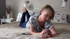 Stock Video Laying On A Bed Checking Her Smartwatch Animated Wallpaper