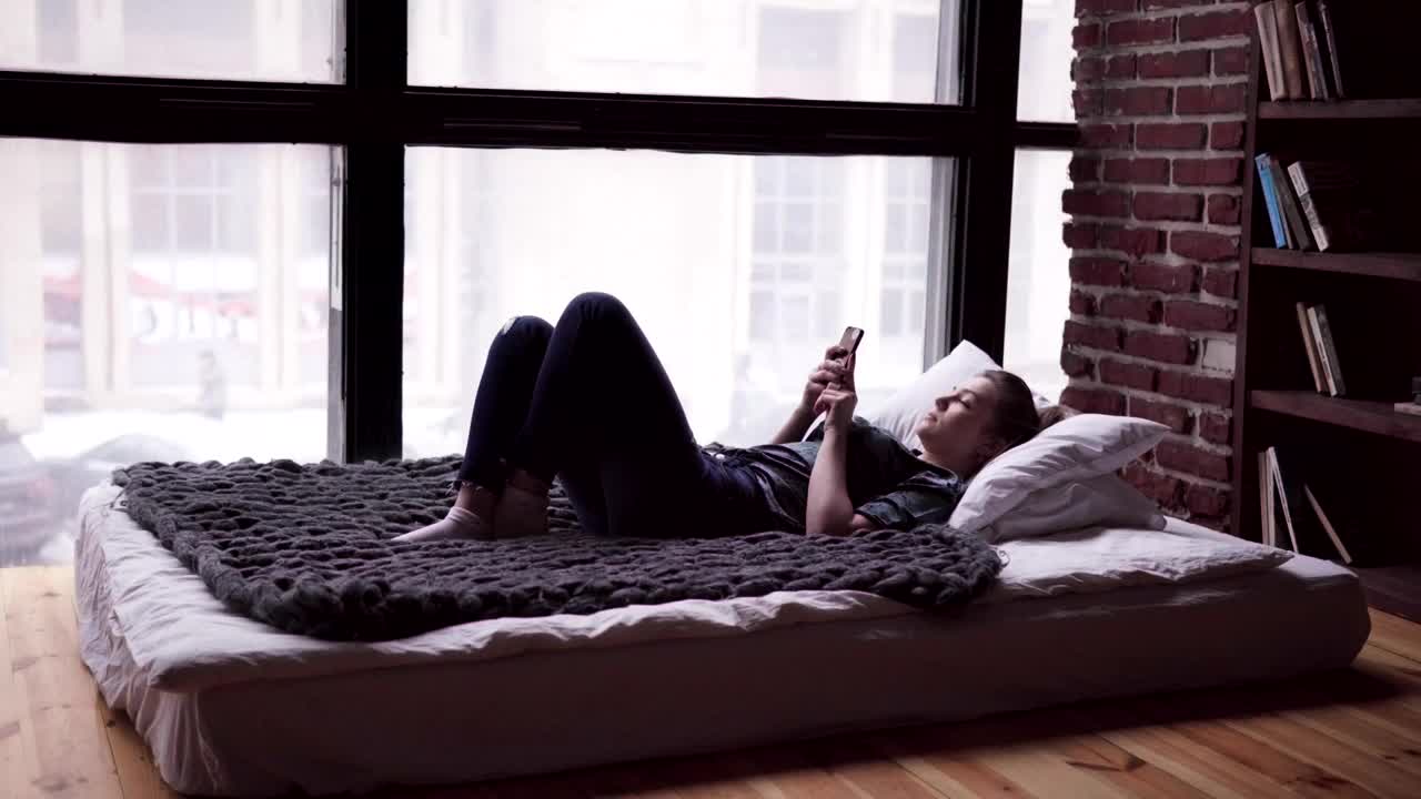 Download Stock Video Laying In Bed With Her Phone Animated Wallpaper