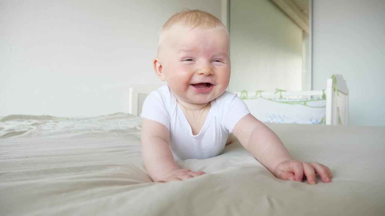 Download Stock Video Laughing Baby On Bed In White Room Animated Wallpaper