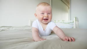 Stock Video Laughing Baby On Bed In White Room Animated Wallpaper