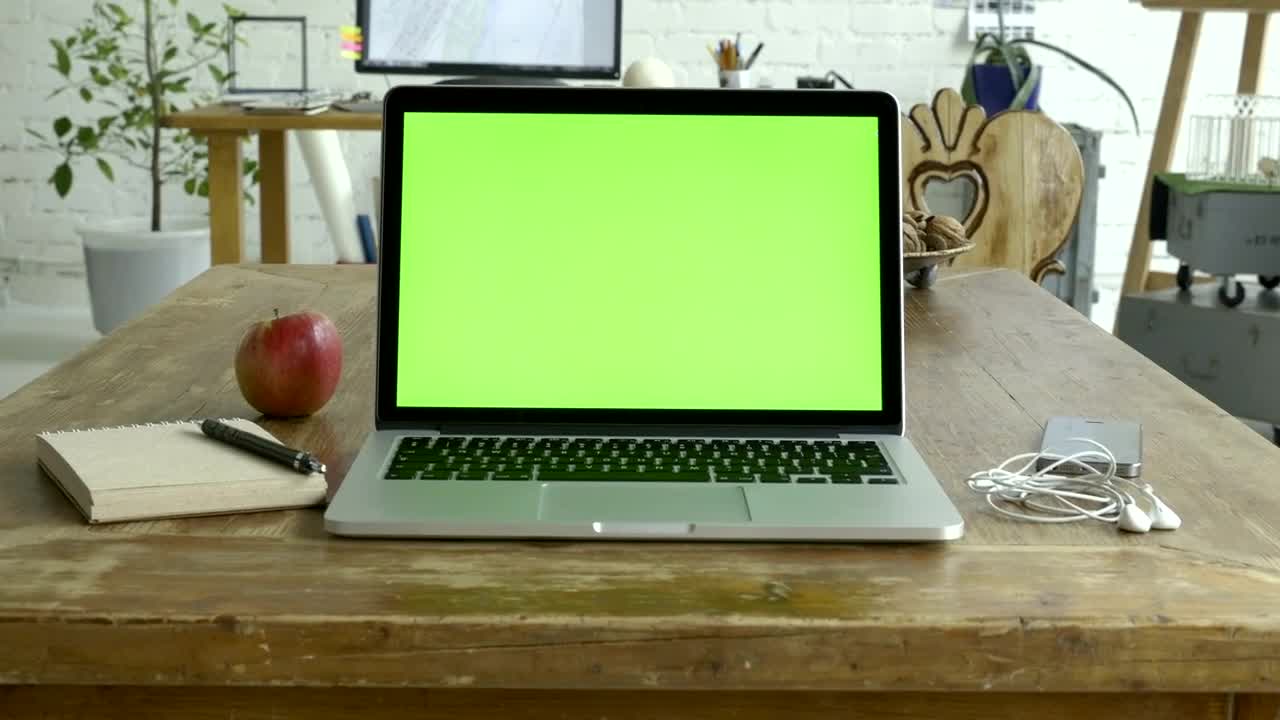 Download Stock Video Laptop With A Green Screen Over The Table Animated Wallpaper