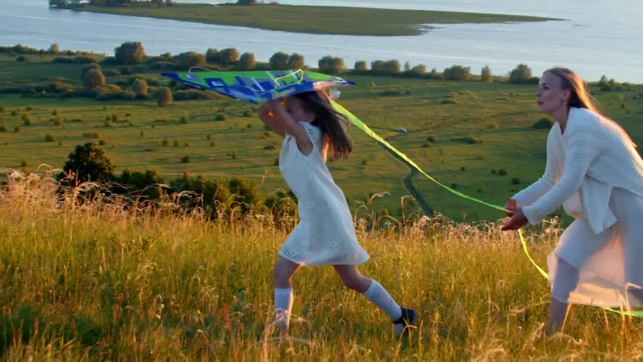 Download Stock Video Mother With Her Daughter Running On The Field With Animated Wallpaper