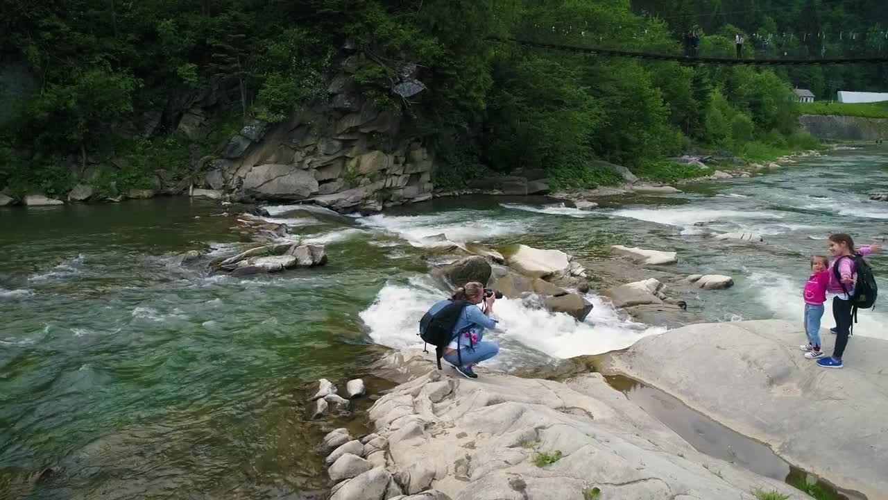 Download Stock Video Mother Taking Photos In The River With Her Daughter Animated Wallpaper