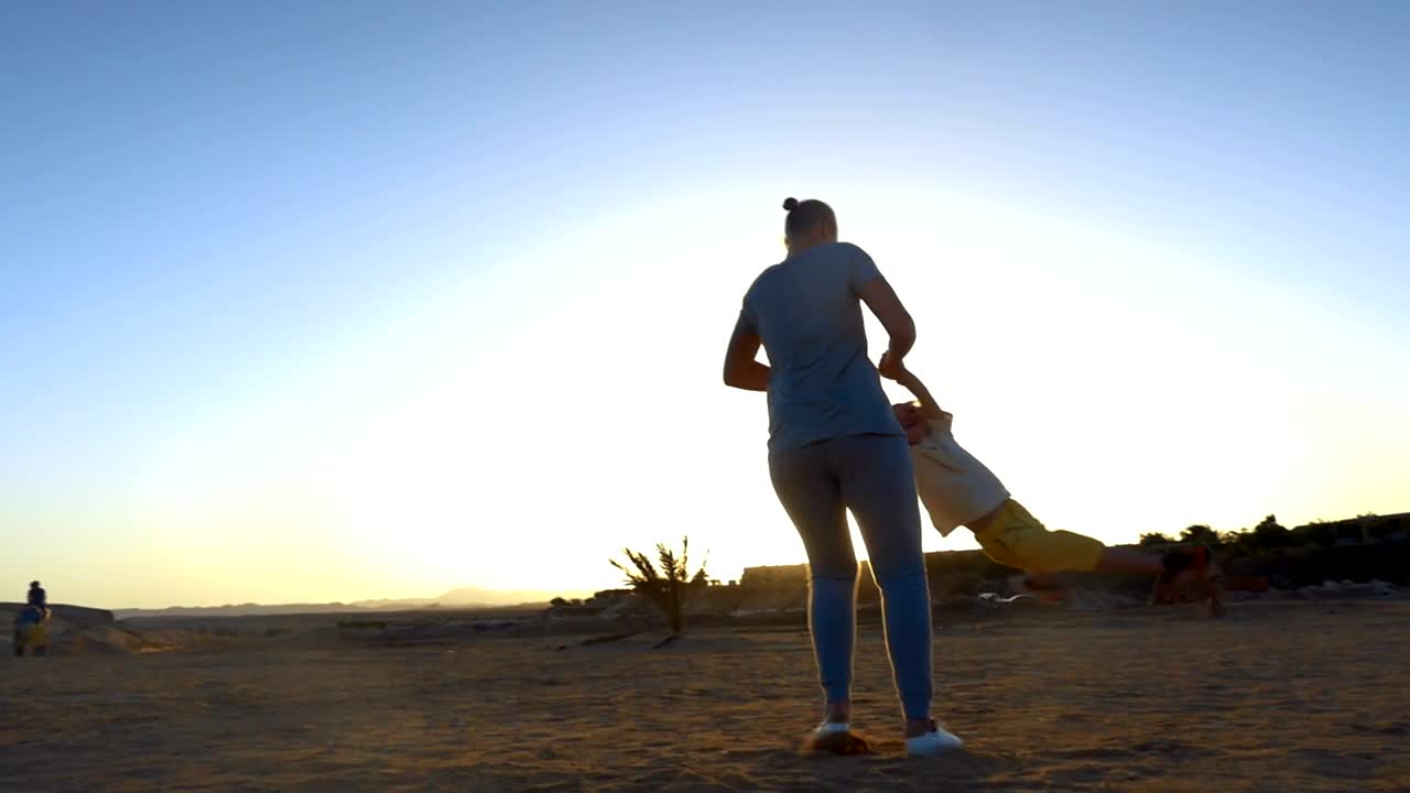 Download Stock Video Mother Swinging Her Child Around At The Beac Animated Wallpaper