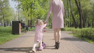 Stock Video Mom Leads Daughter On Scooter Through Par Animated Wallpaper