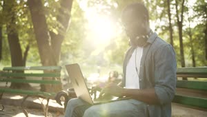 Stock Video Man Working On Laptop In Park With Light Leaks Throug Animated Wallpaper
