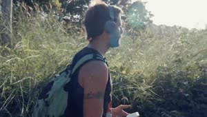 Stock Video Man Walking In Nature With Music On His Headphone Animated Wallpaper